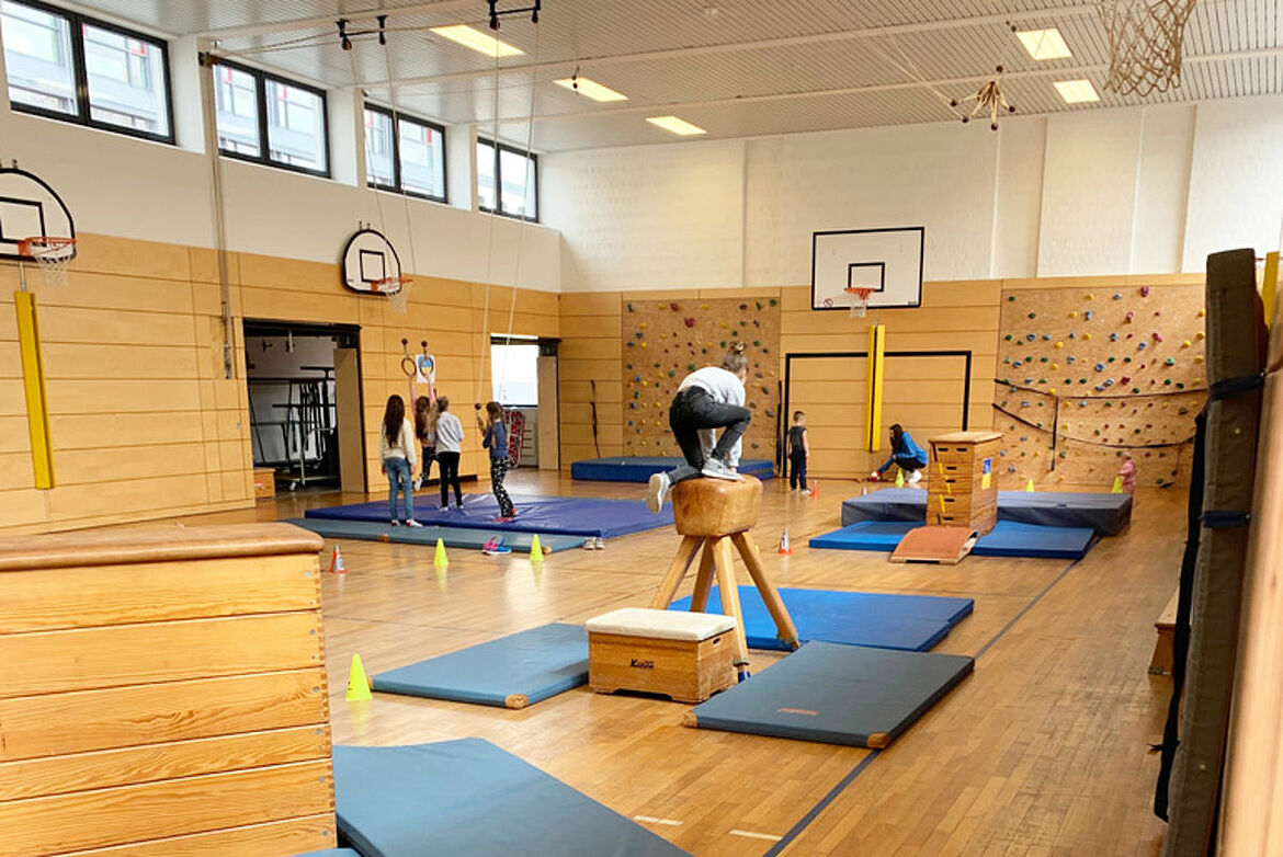 Eine Sporthalle mit einem Parkour aus Turngeräten.